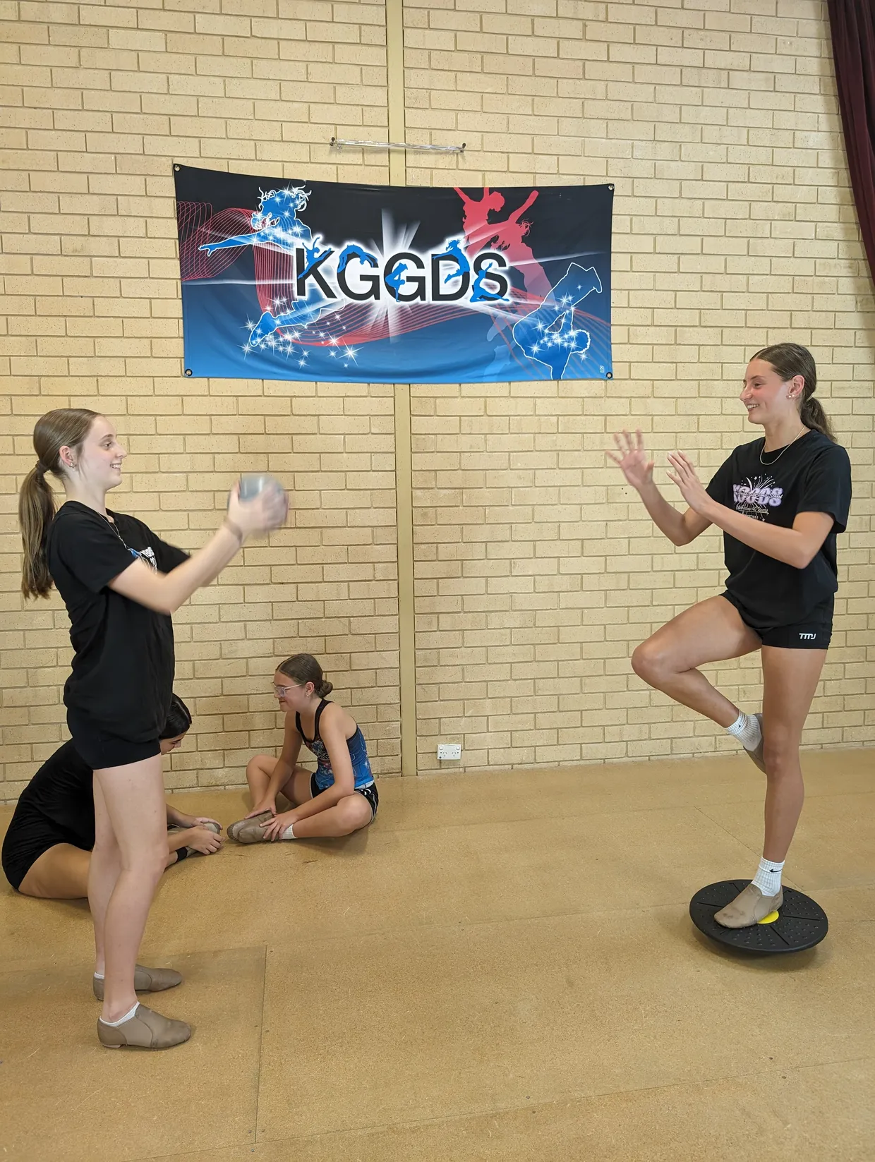 A group of Fitness students helping eachother exercise.