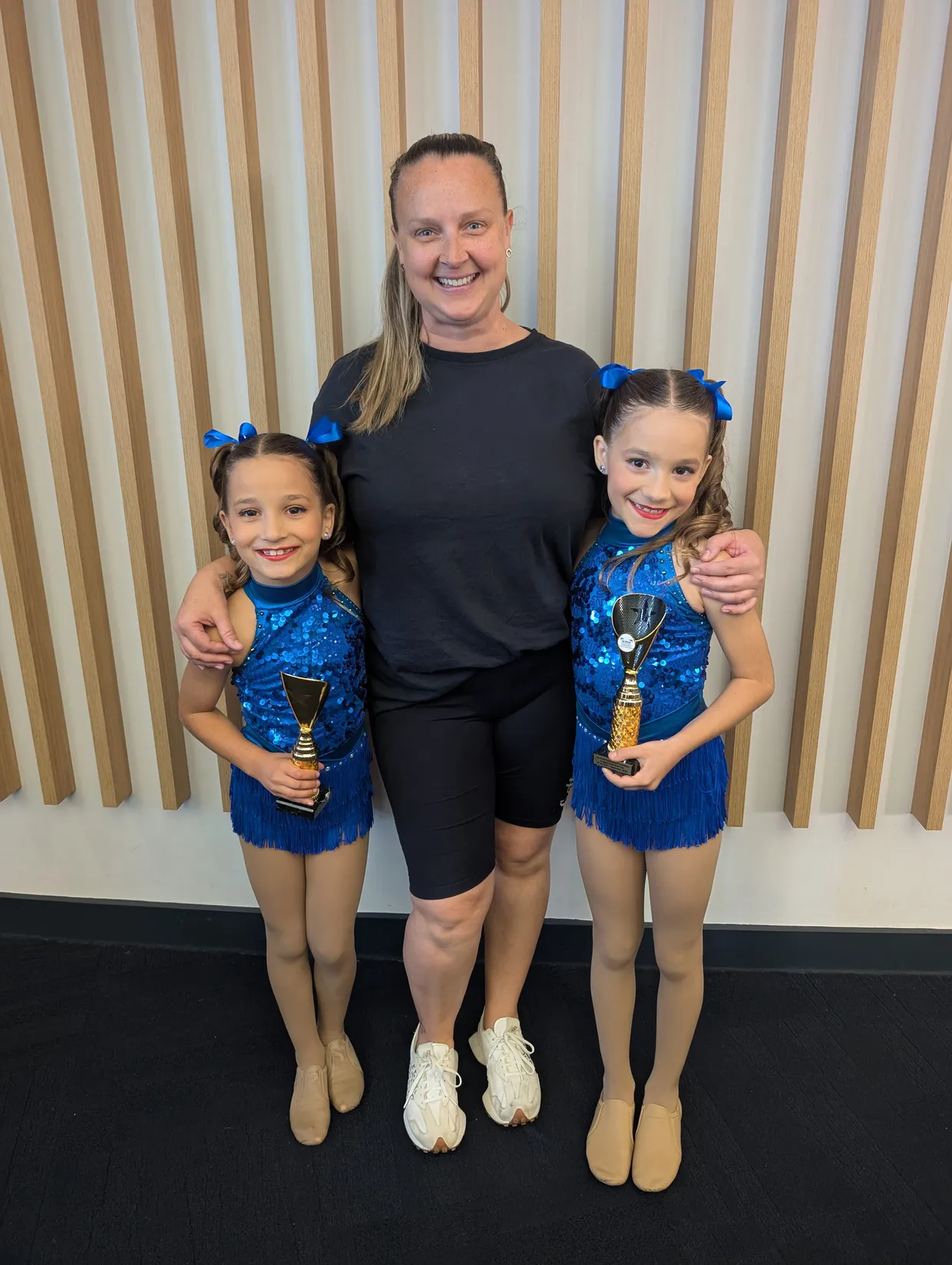 NIkita and 2 private lesson students holding awards they won at dance competitions.