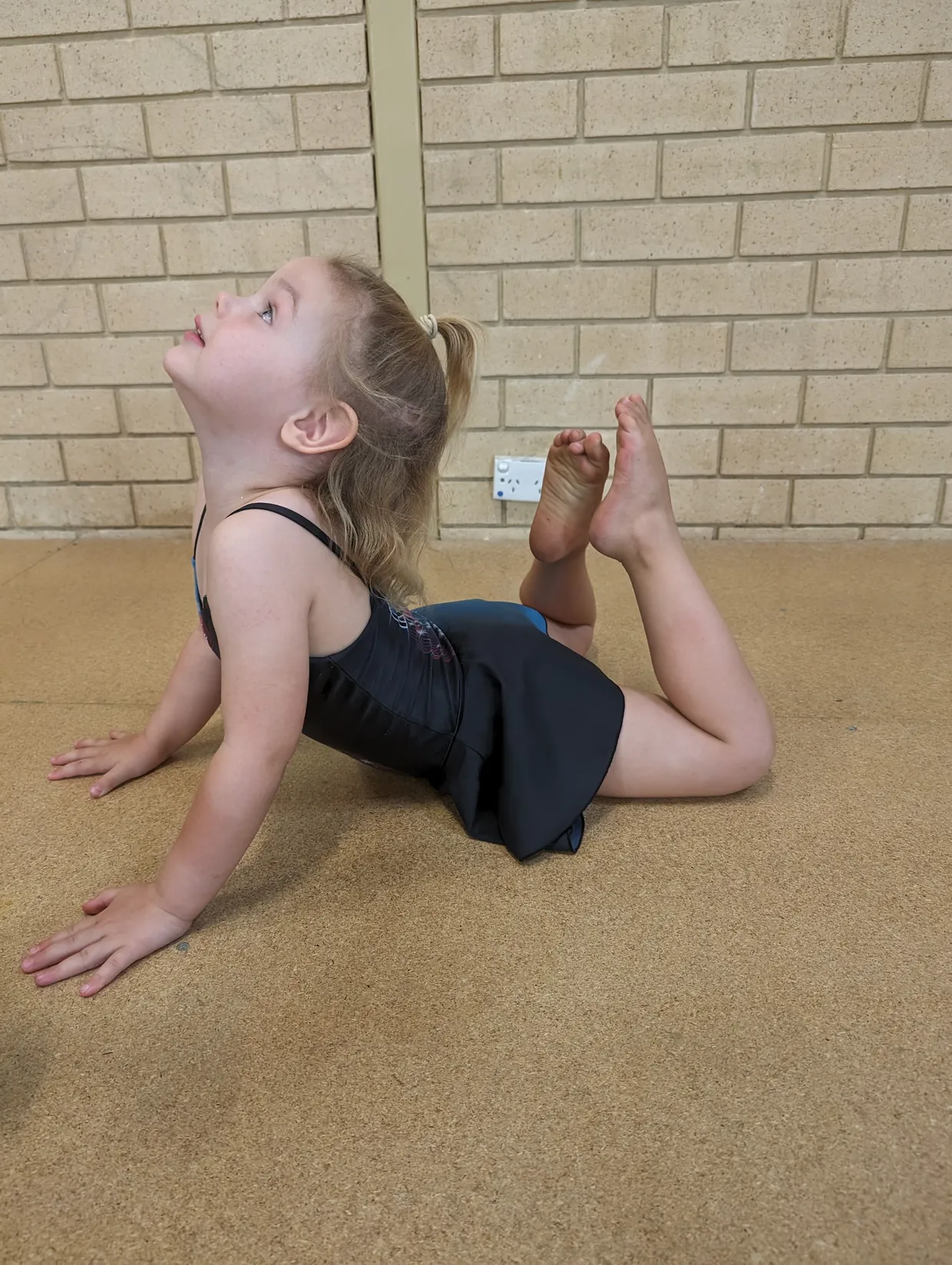 A Tumble student practising toes touch head.